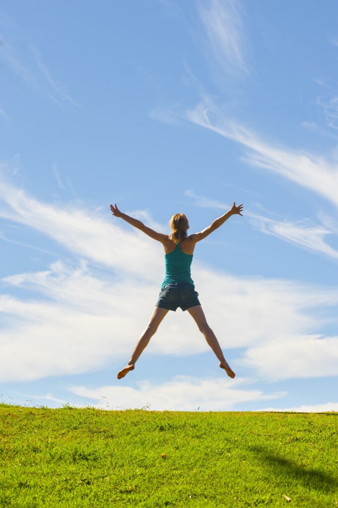 Happy woman jumping for joy, celebrating winning and enjoying happiness of freedom and carefree life